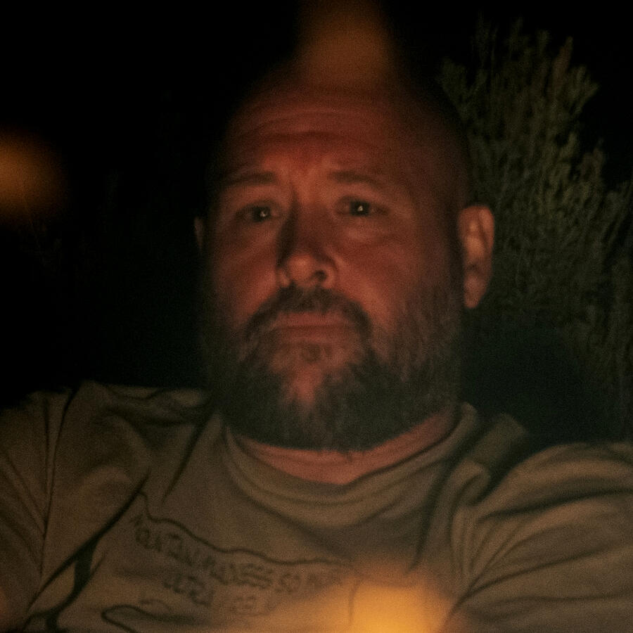 Ex-Mormon man wrestling with meaninglessness and existential angst. Image of a man staring into a fire, conveying the disorientation one feels after deconstructing their childhood faith tradition.